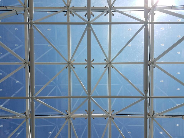 katto, jossa on paljon metallisia tukirakenteita ja taivas - Valokuva, kuva