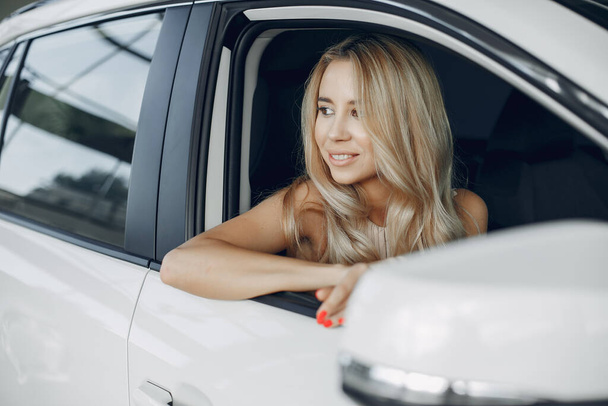 Stylish and elegant woman in a car salon - Zdjęcie, obraz