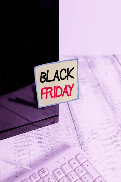 Handschriftlicher Text Black Friday. Konzept bedeutet einen Tag, an dem Verkäufer ihre Preise ausschließlich für Käufer festlegen Notationspapier, das auf einen schwarzen Computerbildschirm nahe der weißen Tastatur geklebt ist. - Foto, Bild