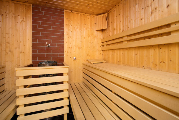 sauna interior with wooden floor and fireplace - Photo, Image
