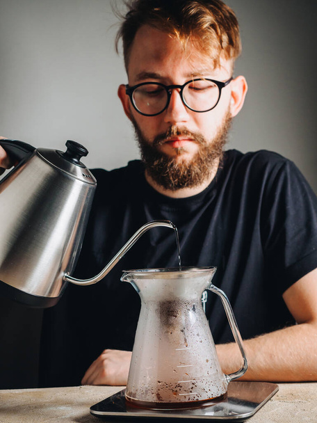 Making filter coffee with kettle for brewing by man. - Zdjęcie, obraz