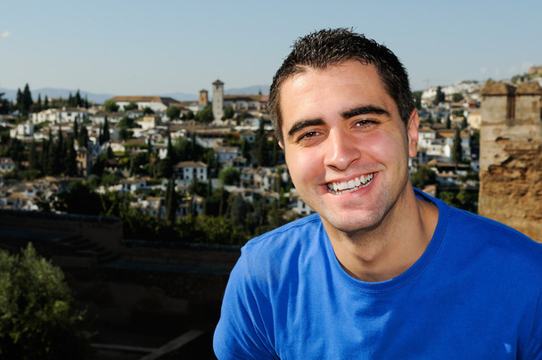 Привлекательный портрет улыбающегося мужчины на городском фоне
 - Фото, изображение