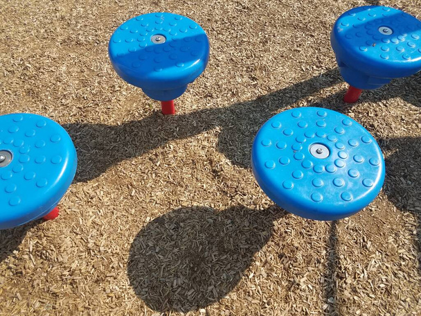 taburetes paso azul en el patio de recreo con virutas de madera
 - Foto, imagen