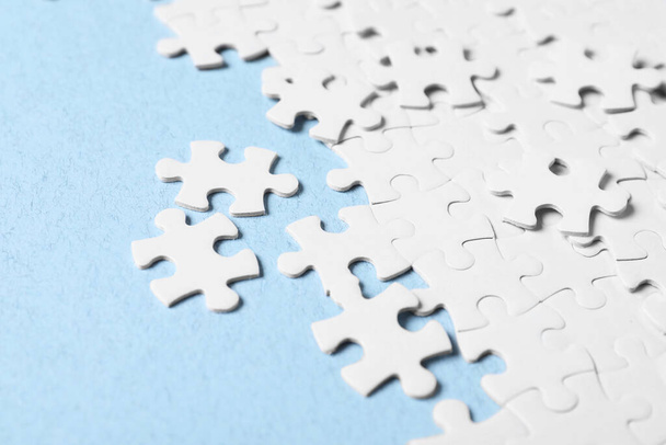 Blank white puzzle pieces on light blue background - Foto, Imagen