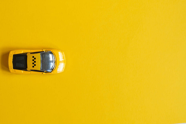 Toy taxi auto na žlutém pozadí s kopírovacím prostorem - Fotografie, Obrázek