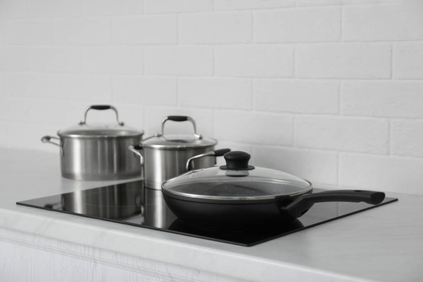 New cookware on induction stove in kitchen - Foto, afbeelding