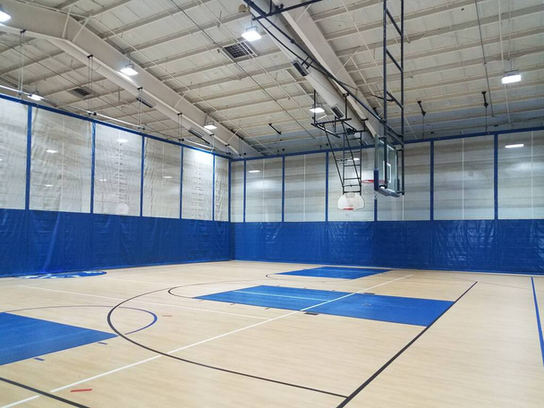 quadra de basquete com aros e piso de madeira no ginásio ou ginásio
 - Foto, Imagem