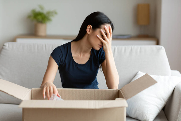 Dívka vybalení box frustrovaný s nesprávným balíčkem sedí doma - Fotografie, Obrázek