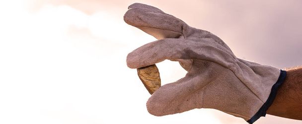 золотий камінь крупним планом в руці гірничодобувної компанії з рукавичкою. Концепція гірничих досліджень
. - Фото, зображення