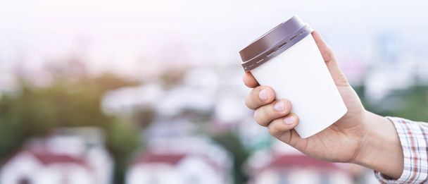 Maquette d'une main masculine tenant une tasse de papier café isolée  - Photo, image