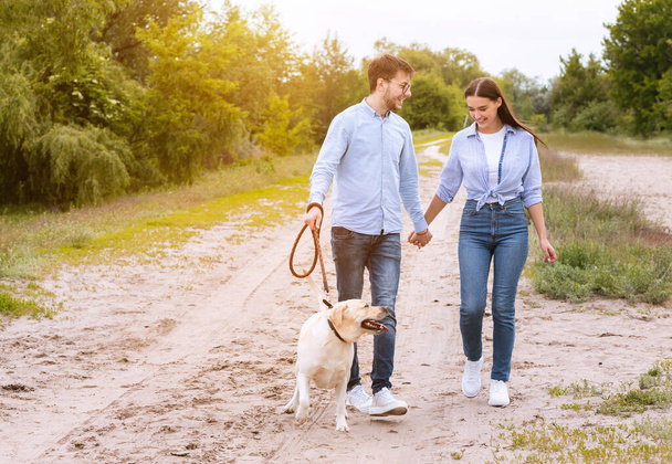 Roztomilý pár a labrador procházky spolu na venkově - Fotografie, Obrázek