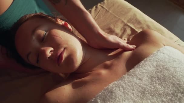 Therapist hands make neck and shoulder massage for young caucasian woman - Felvétel, videó
