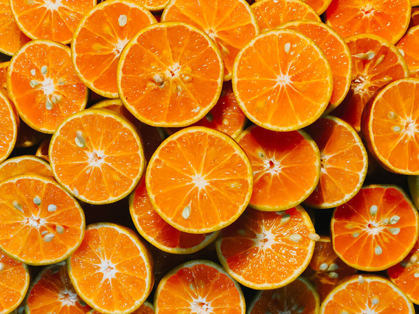 新鮮な刻んだオレンジスライス食品の背景、背景を作るために使用するための新鮮なオレンジの色、市場で販売するためのオレンジスライス、オレンジカットジューシーで健康的なフルーツドリンク. - 写真・画像