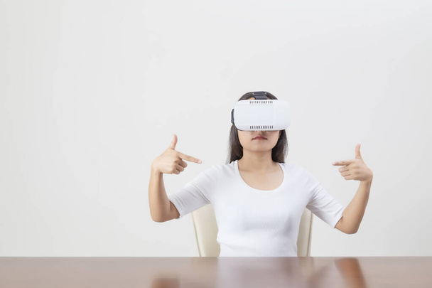 Fiatal nő jár, miközben visel VR eszköz vagy virtuális valóság szemüveg fehér háttér. - Fotó, kép