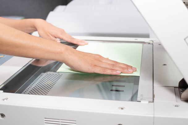 donna mano mettendo un foglio di carta in un dispositivo di copia
 - Foto, immagini