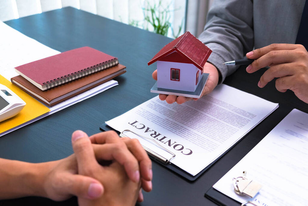 Zaproponować umowę na podpisanie umów kupna domów i nieruchomości, obliczyć stawki zakupu domu, przekazać klucze do domu i polecić domy. - Zdjęcie, obraz