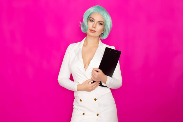 Beautiful young woman with short blue hair in a white business dress jacket holding a black folder with documents - Zdjęcie, obraz