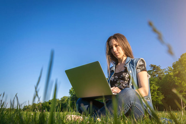 Business outside. Student girl work with laptop, computer tablet in summer park. Online technology with woman outdoor. Escaped of office distance education concept. - 写真・画像