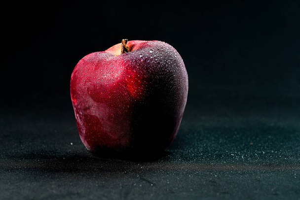 fresh and delicious red apple isolated against black background, with water droplets on the apple, selective focus - Zdjęcie, obraz