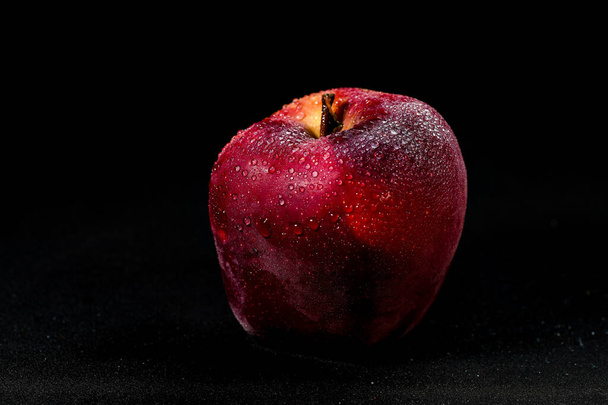 pomme rouge fraîche et délicieuse isolée sur fond noir, avec des gouttelettes d'eau sur la pomme, mise au point sélective - Photo, image
