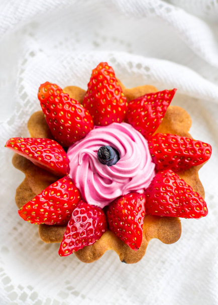 όμορφο νόστιμο cupcake close up με φράουλες, αγιόκλημα και ροζ κρέμα - Φωτογραφία, εικόνα
