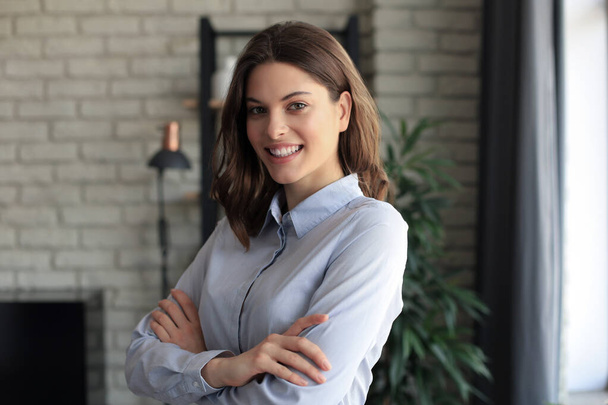 Attractive business woman smiling while standing in the office - Valokuva, kuva