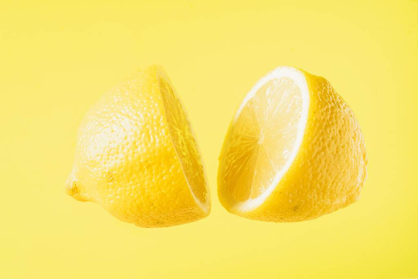 Limón en rodajas flotando sobre fondo amarillo
 - Foto, imagen