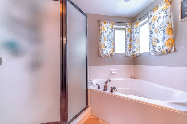 Badkamer gebouwd in bad en douchecabine met ingelijste glazen behuizing - Foto, afbeelding