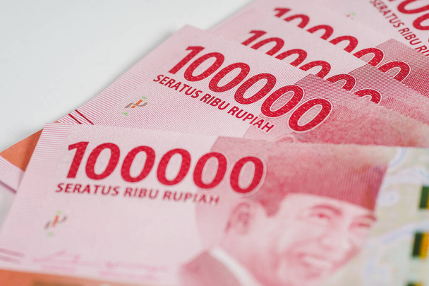 インドネシア・ルピアの通貨ノートは、白い背景に対して隔離された10万の宗派で - 写真・画像