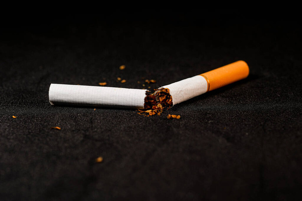 stop smoking concept, a broken cigarette isolated against black, World Tobacco Day - Foto, Bild