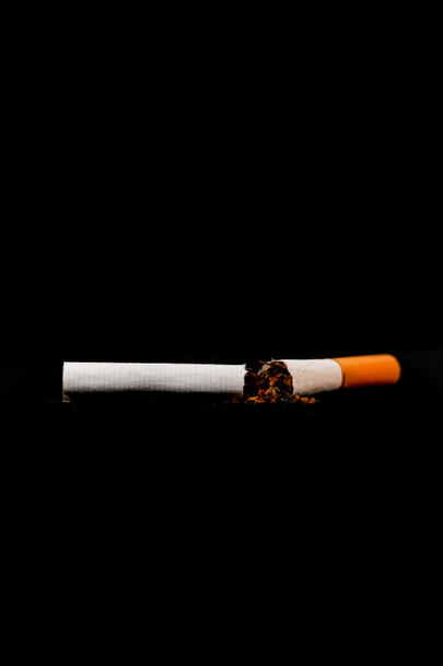 cesser de fumer concept, une cigarette cassée isolée contre le noir, Journée mondiale du tabac - Photo, image