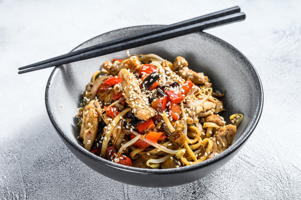 Udon stir-fry noodles with chicken meat and sesame. Gray background. Top view. - Photo, Image