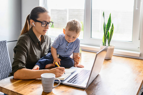 Young mother works from home with laptop - Photo, Image