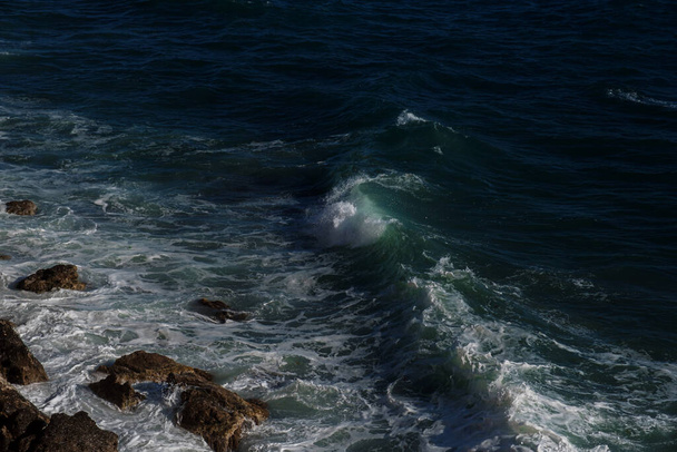 Oceaan golf achtergrond breken zee water rotsachtige kust ruwe zeeën turquoise water gradiënt schuim. Grote golven op open zee. Zomer moesson. Witte heuvelrug van een zeegolf. - Foto, afbeelding