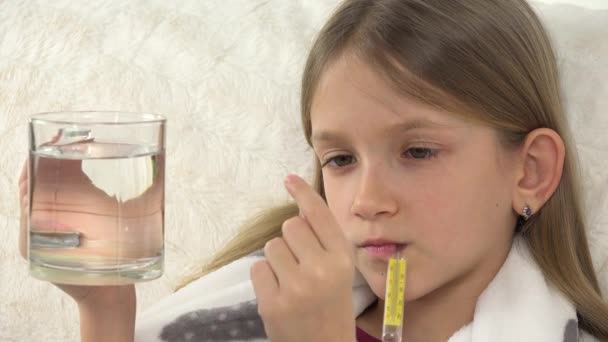 Sick Kid with Thermometer, Drinking Drugs with Water, Child Drinks Pills, Sad Ill Girl Face on Sofa - Кадри, відео