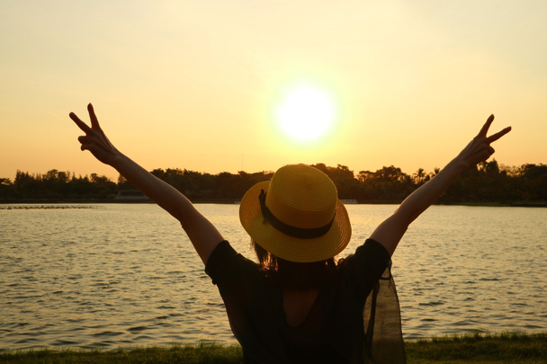 美しい日の出と幸せな腕を上げる女性のシルエット - 写真・画像