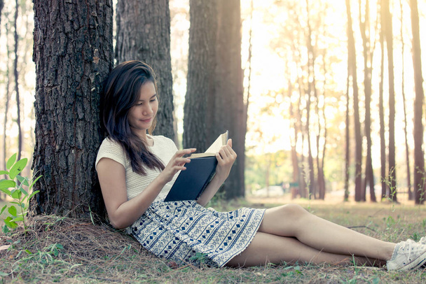 Junge asiatische Frau liest ein Buch im Park in Vintage-Farbton - Foto, Bild