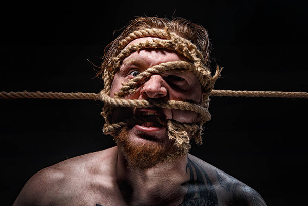 Foto di uomo barbuto legato con corda sul viso
 - Foto, immagini
