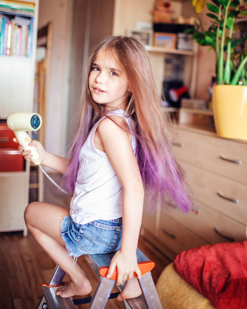 Schoonheidssalon thuis. Eerste haarkleurervaring. Meisjeskracht. Schattig 7-8 jaar oud meisje met lang haar met kleurverloop haareffect, online cursussen, thuis blijven voor coronavirus wereldwijd pandemie - Foto, afbeelding