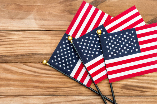 Three small american flags on wooden background. Top view. Copy space. - Photo, Image