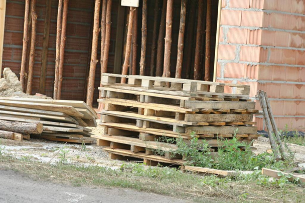Упаковка поддонов на строительной площадке рядом с домом
 - Фото, изображение