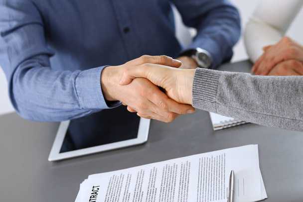 Group of business people shaking hands after discussing questions at meeting in modern office. Handshake close-up. Teamwork, partnership and agreement in business concept - Photo, image