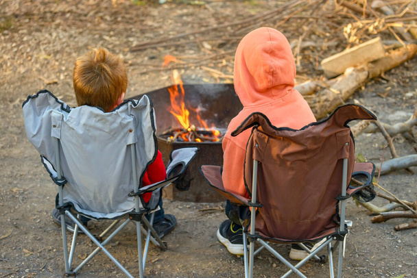 Dzieci palące ogień na polu namiotowym lasu Kuitpo podczas ferii zimowych, Australia Południowa - Zdjęcie, obraz