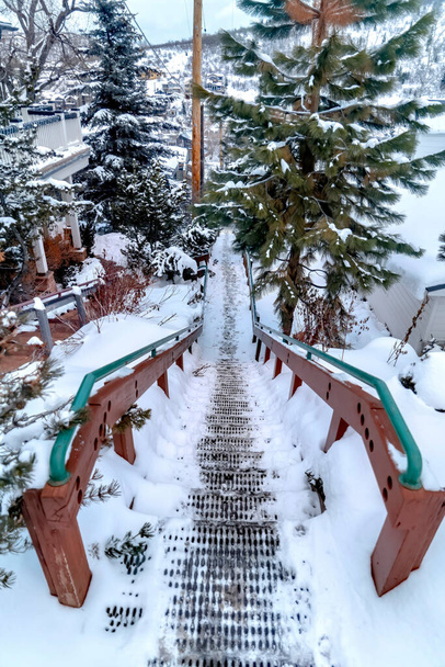 Σκάλες μέσα στη γειτονιά και γραφικό λόφο σκεπασμένο με λευκό χιόνι το χειμώνα - Φωτογραφία, εικόνα