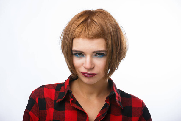 Beautiful modern girt with stylish haircut. Red hair. Checkered shirt. - Фото, изображение