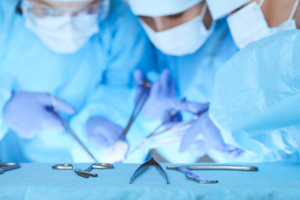 Close-up of medical team performing operation. Group of surgeons at work are busy of patient. Medicine, veterinary or healthcare and emergency in hospital - Foto, afbeelding