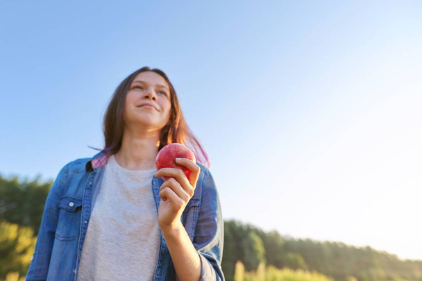 Young happy woman with red apple, girl biting an apple - Photo, image