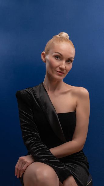 Young athletic exhausted posing on camera, beautiful in a tuxedo dress background blue day. Make up - Valokuva, kuva