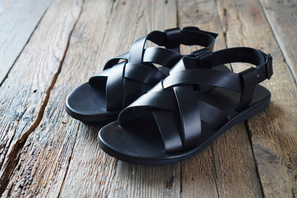New leather men's sandals on the weathered wooden background. Summer footwear.  - Fotó, kép