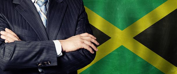 Férfi kéz ellen jamaikai zászló háttér, üzleti, politikai és oktatási Jamaica koncepció - Fotó, kép